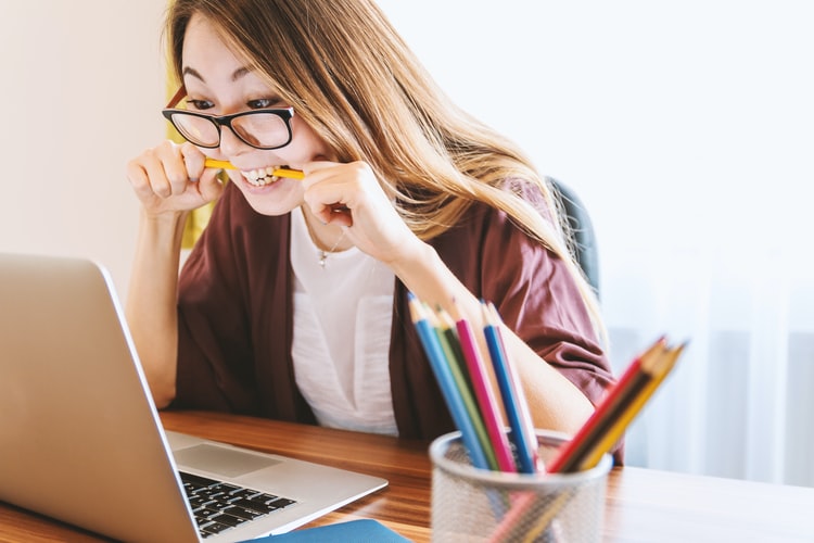 girl stressed and biting her pen