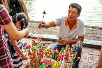 vendor giving hat candy to the lady 