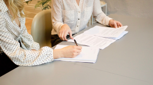 2 women along with documents in the table