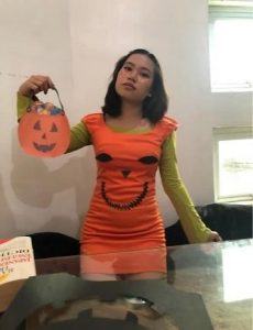 Girl in orange dress holding a pumpkin