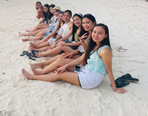 Grow Forward JP Inc female employees sitting at the white sand of Boracay