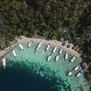 Top View of beach having white sand and 15 boats